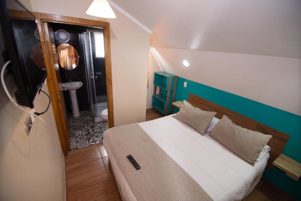 1 dormitorio con cama y baño con espejo. en Hostal Terraza Recreo, en Viña del Mar