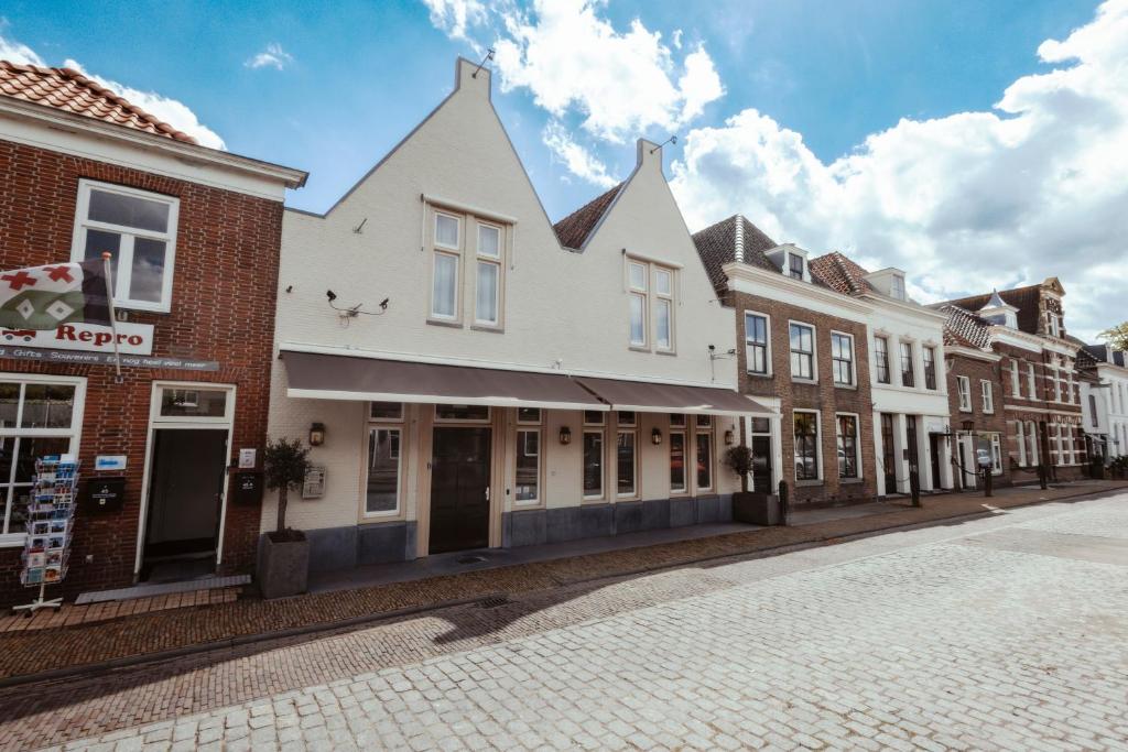 une rangée de bâtiments dans une rue pavée dans l'établissement Hotel de MAGISTRAAT, à Willemstad