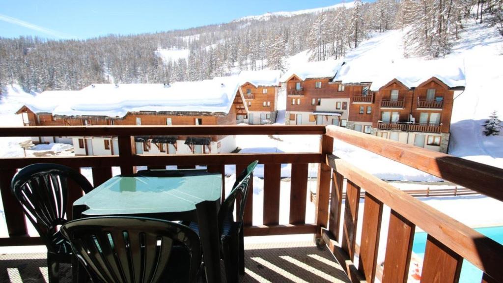 - une table et des chaises sur le balcon d'un lodge de ski dans l'établissement Résidence Parc Aux Etoiles - C307PAE - APPARTEMENT 2 CHAMBRES AVEC BALCON MAE-8724, à Narreyroux