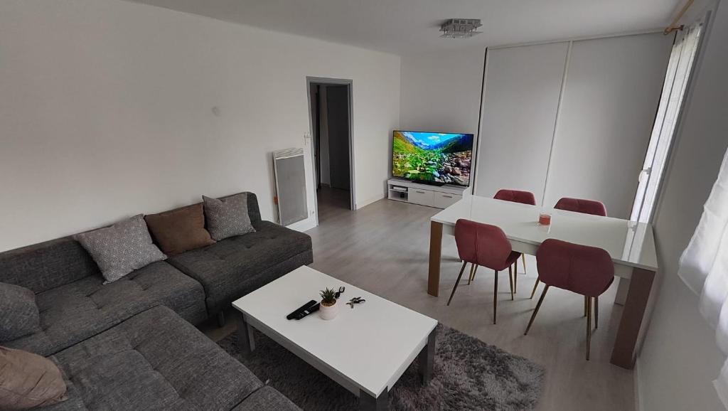 un salon avec un canapé, une table et une télévision dans l'établissement Appartement Montpellier Sud 3 pièces, à Montpellier