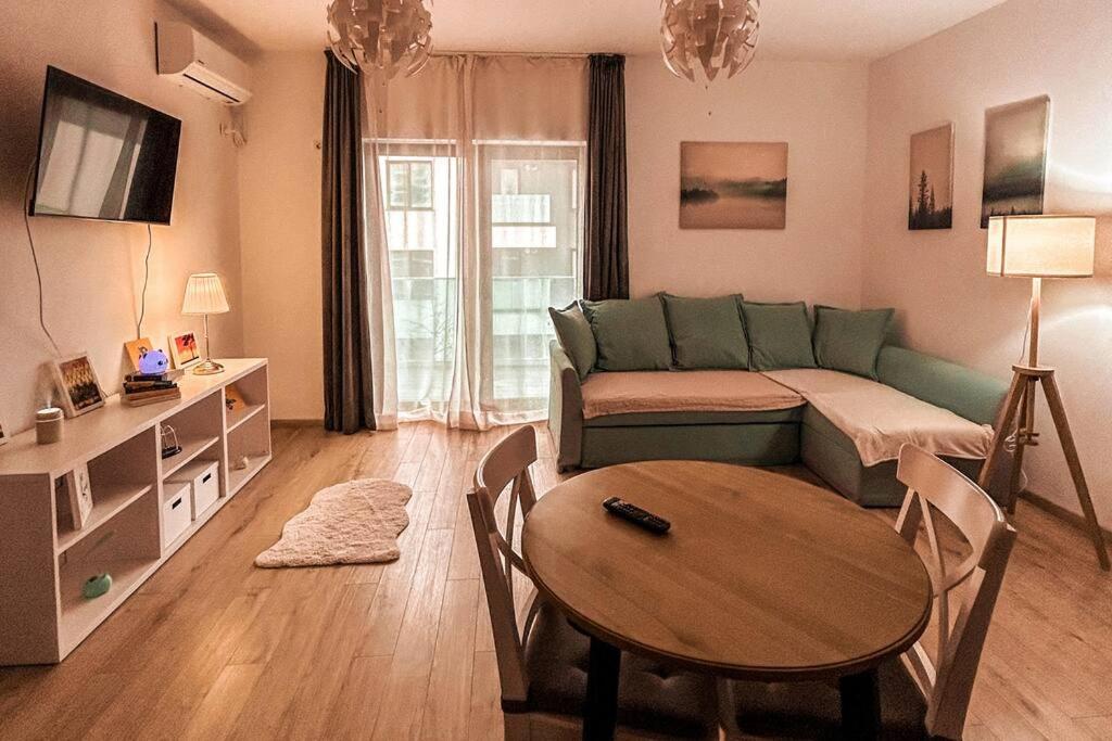 a living room with a green couch and a table at 2 Șic rooms Park Copou AB Homes in Iaşi