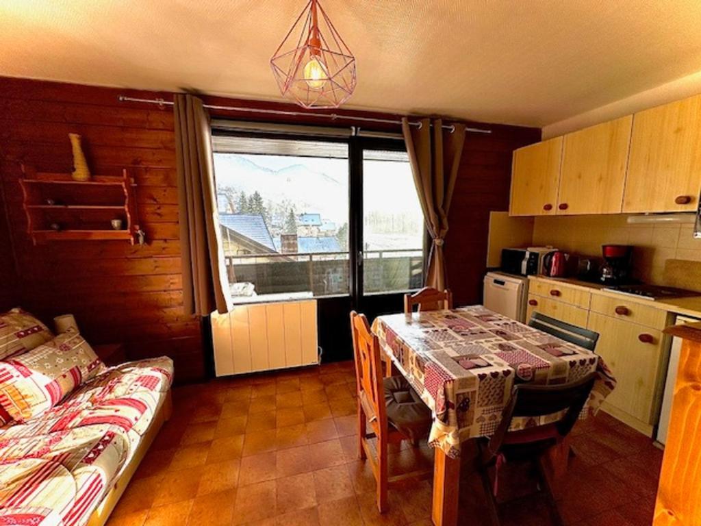 une cuisine avec une table et une salle à manger dans l'établissement Charmant studio au cœur du village avec balcon, idéal pour 2-3 pers, proche commodités ! - FR-1-692-96, à La Chapelle-dʼAbondance