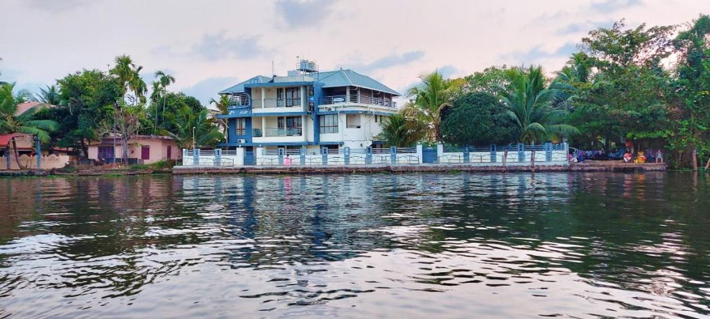 ein großes Haus am Ufer eines Wasserkörpers in der Unterkunft Captains Cabin backwater resort in Alappuzha