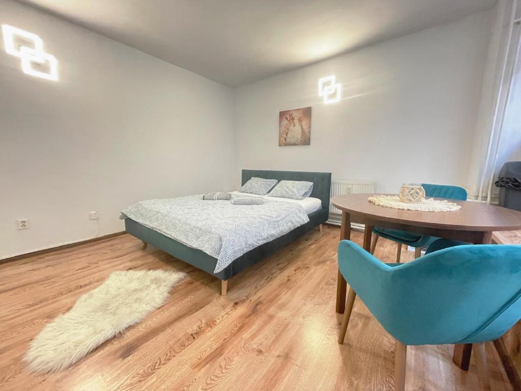 a bedroom with a bed and a table and chairs at Central Apartment NEW STUDIO in Košice