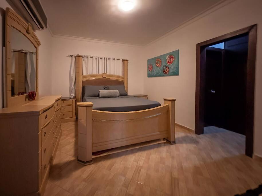 1 dormitorio con cama de madera y vestidor en LaPileta809, en La Romana