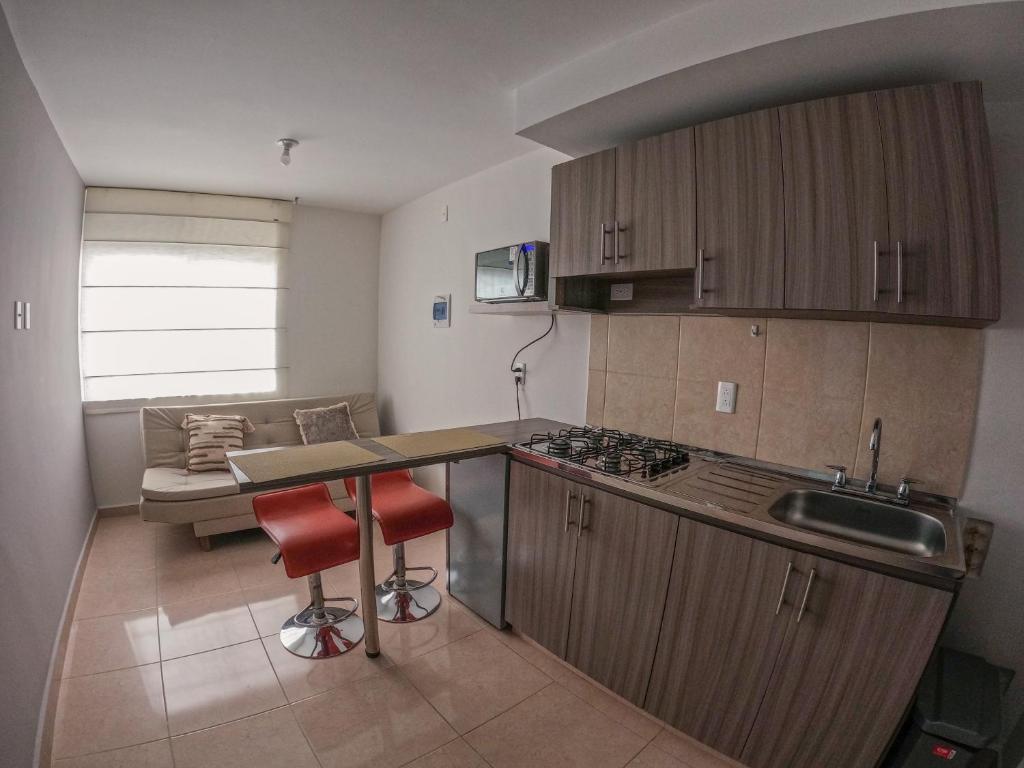 a kitchen with a counter and a sink and a stove at Apartaestudio Norte de Armenia in Armenia