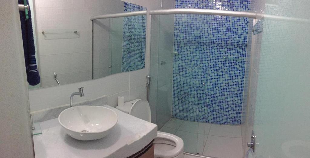 La salle de bains est pourvue d'un lavabo, d'une douche et de toilettes. dans l'établissement Casa Amarela - Raiô Baixú Hospedagem, à Caraíva