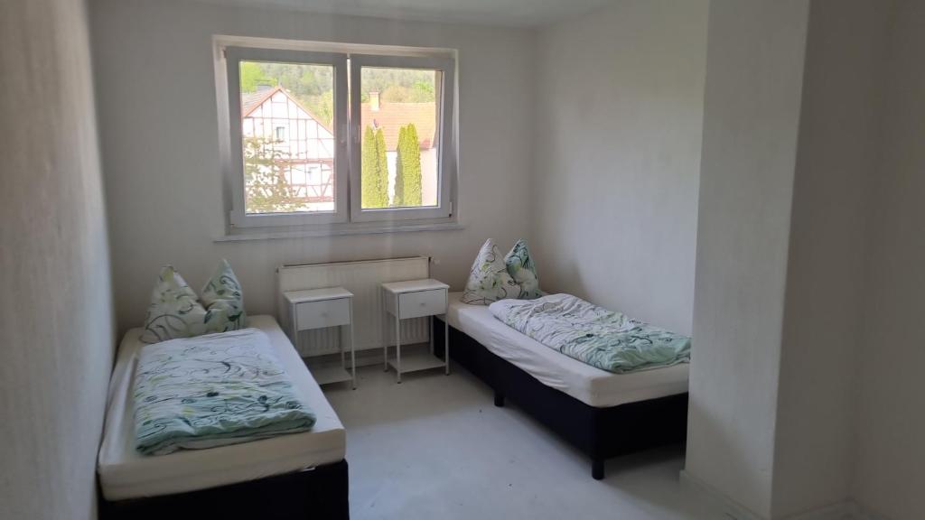 a small room with two beds and a window at Herberge Kleine Lea Gemeinschaftsbad KEIN WiFi Keine Heizung in Richelsdorf