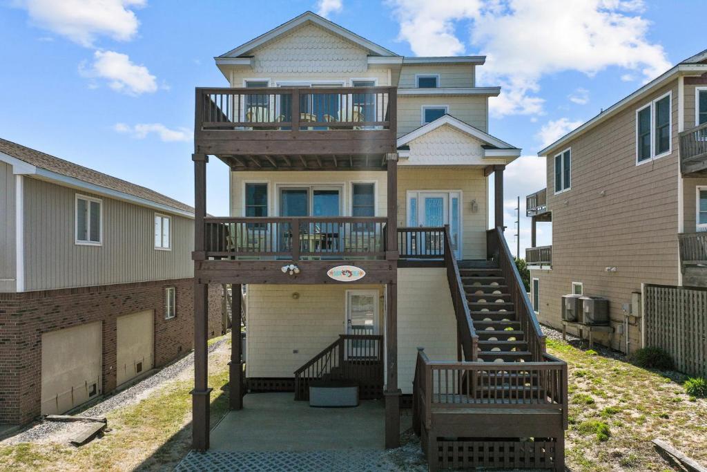 uma casa com uma varanda na parte da frente em 5711 - OBX Ta SEA by Resort Realty em Nags Head