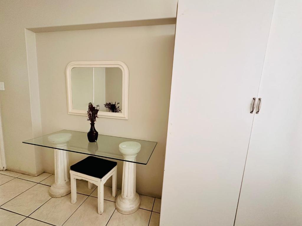 a table with a vase on it in a room at Nomacurvy beach front accommodation in Durban