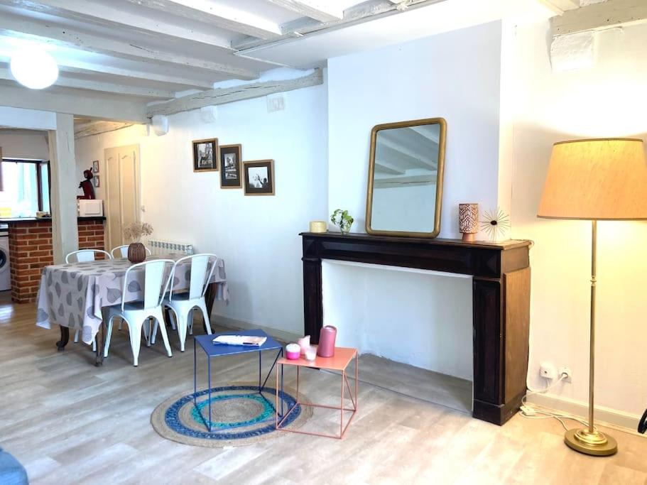 un salon avec une table et un miroir sur une cheminée dans l'établissement Blois : charmant studio, à Blois