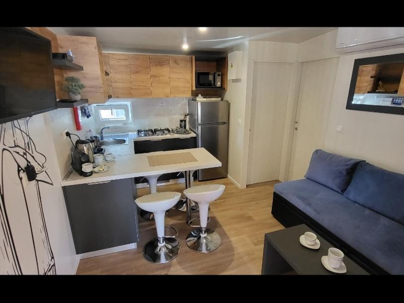 a small kitchen and living room with a blue couch at Mobile home JOY in Biograd na Moru