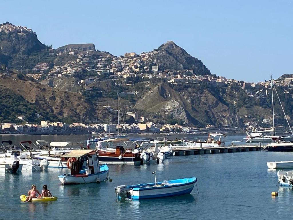 deux personnes dans un radeau dans un port avec des bateaux dans l'établissement Casa TYSANDROS Due passi dal mare, à Giardini Naxos
