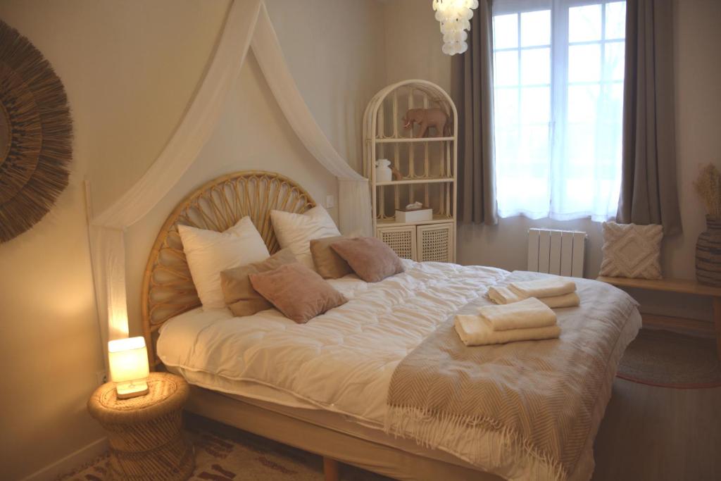 ein Schlafzimmer mit einem großen weißen Bett mit Kissen in der Unterkunft Domaine des cyprès in Vaudrimesnil