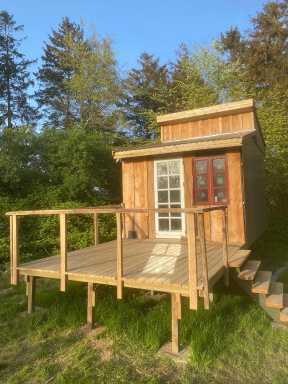 een tiny house met een terras in het gras bij Tinyhouse in Væggerløse