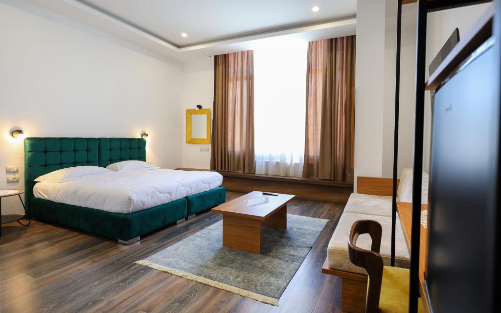 um quarto de hotel com uma cama e uma mesa em Hotel Republika Berat em Berati