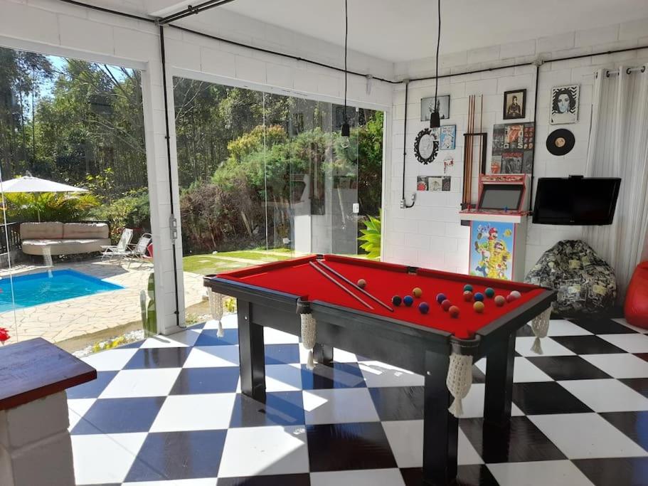 einen Billardtisch in der Mitte eines Wohnzimmers in der Unterkunft Casa para relaxar, estilosa, privativa e pet friendly in Nazaré Paulista