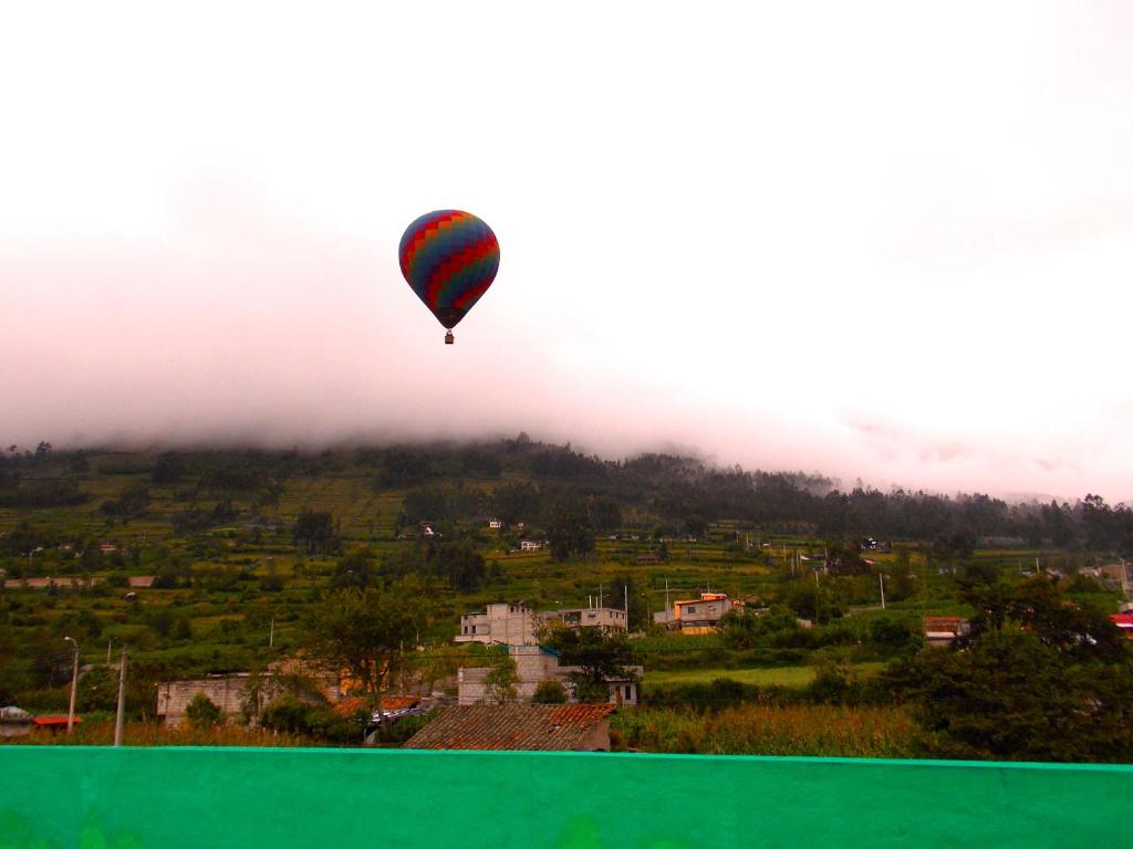 un globo de aire caliente está volando sobre una ciudad en Green House Araque Inn, en Otavalo
