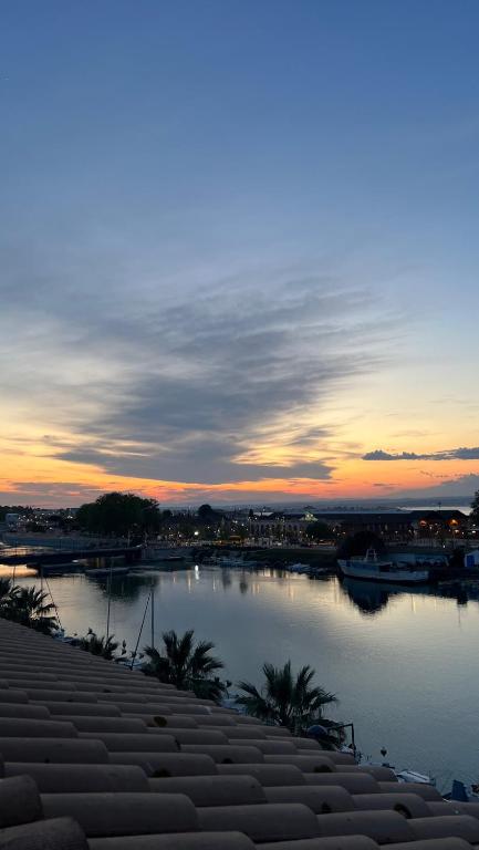 un coucher de soleil sur une étendue d'eau avec des bateaux dans l'établissement Appartement terrasse belle vue en duplex parking, à Sète