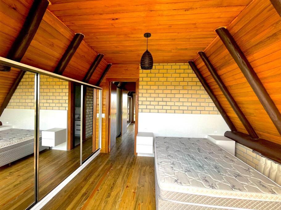 um quarto com uma cama e um tecto de madeira em Chalé Santos em Jaguaruna