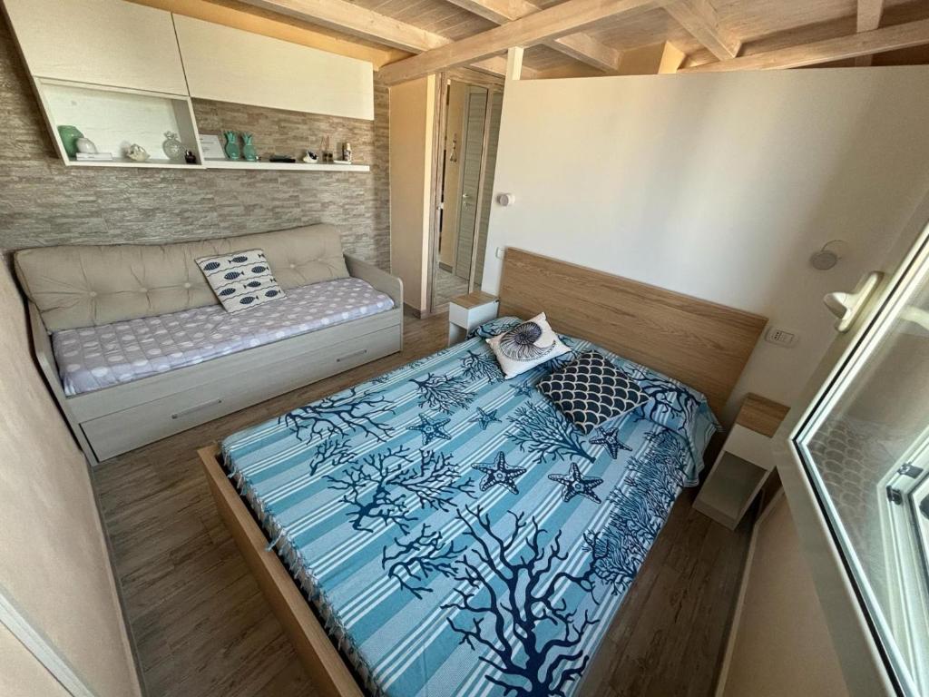 a small room with a bed and a couch at La maison du bonheur in Fontane Bianche