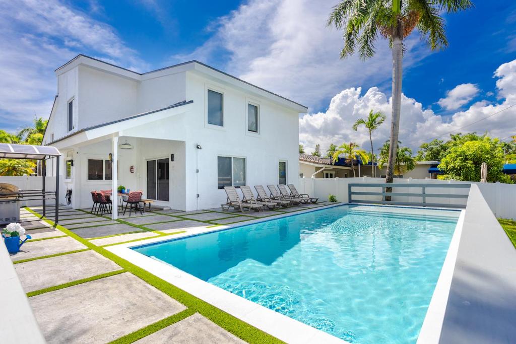 einen Pool vor einem weißen Haus in der Unterkunft Luxury 5BR & 3BA Villa Walk to Hollywood Beach in Hollywood