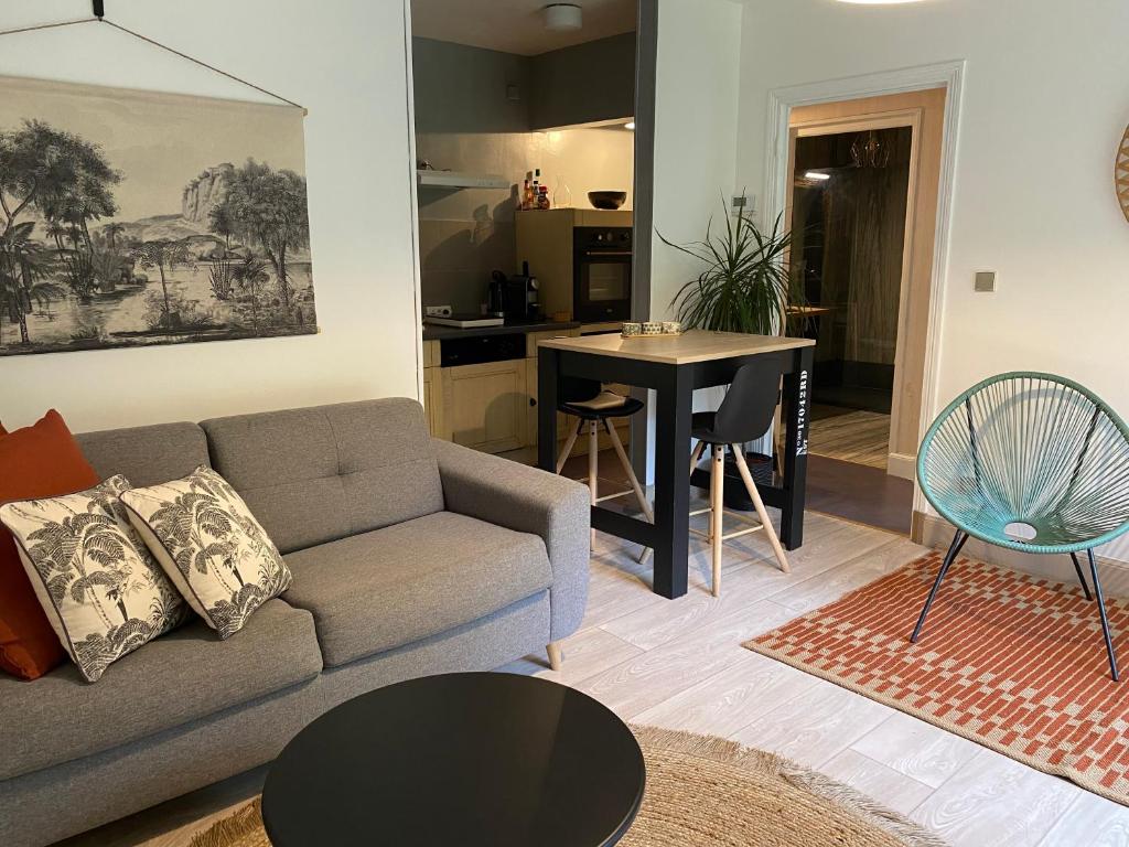 een woonkamer met een bank en een tafel bij logement avec accès piscine in Chaumont-sur-Tharonne