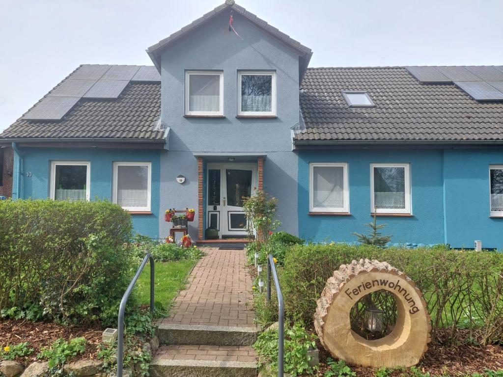 a blue house with solar panels on the roof at Ferienwohnung in Malente