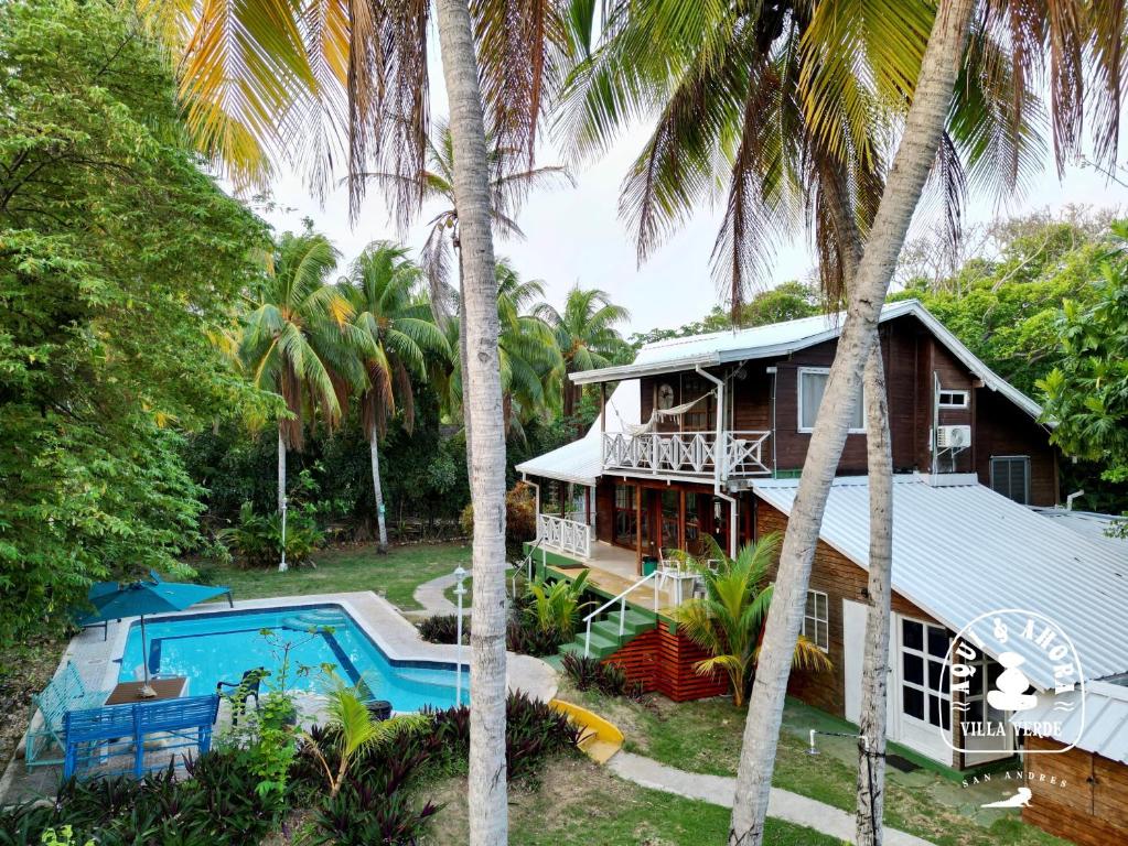 a house with a swimming pool and palm trees at Aqui Ahora at Villa Verde in San Andrés