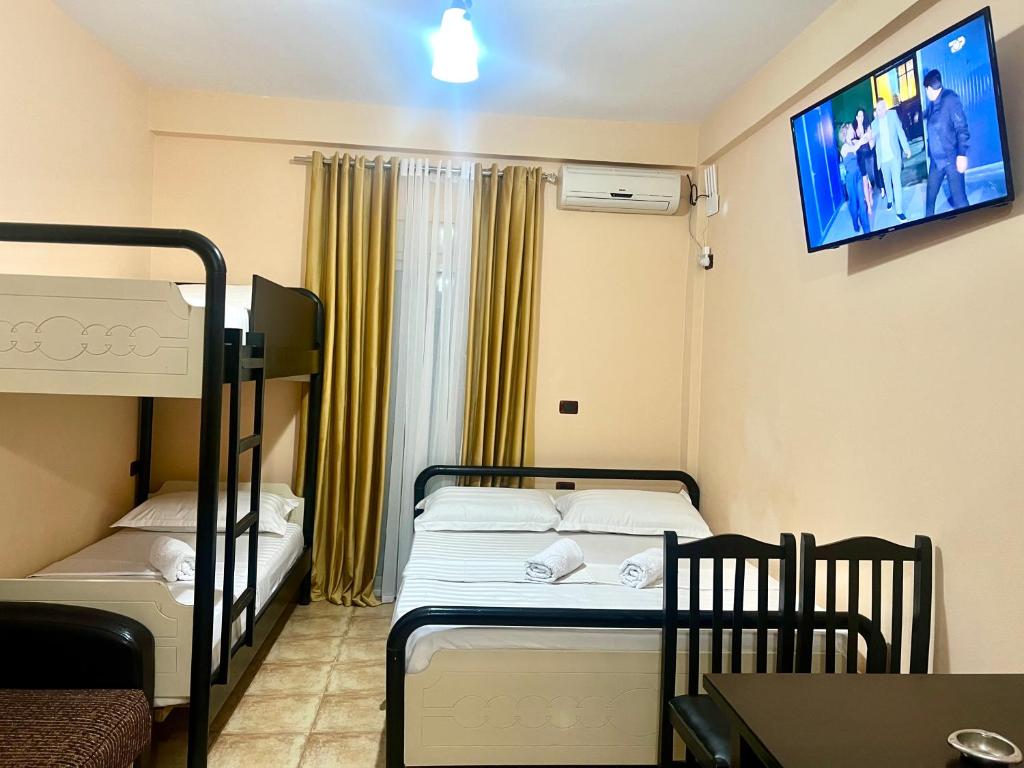 a small room with two bunk beds and a tv at Hotel Asteri in Velipojë