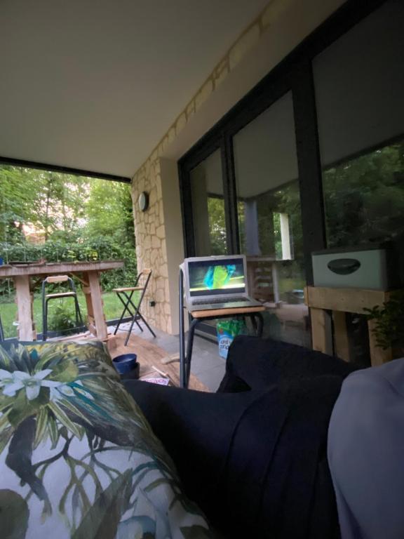 - un salon avec un canapé, une table et des fenêtres dans l'établissement Appartement nature 1h30 de Paris en train, à Saint-André-les-Vergers