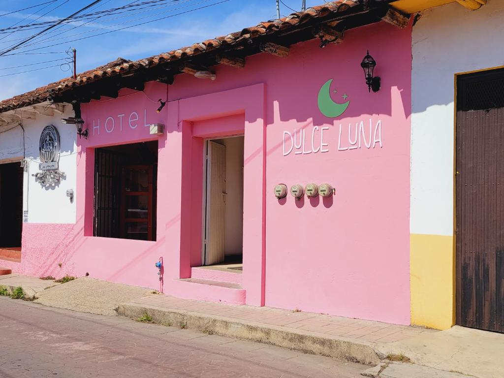 a pink building with a blue luna written on it at Hotel Dulce Luna in San Cristóbal de Las Casas