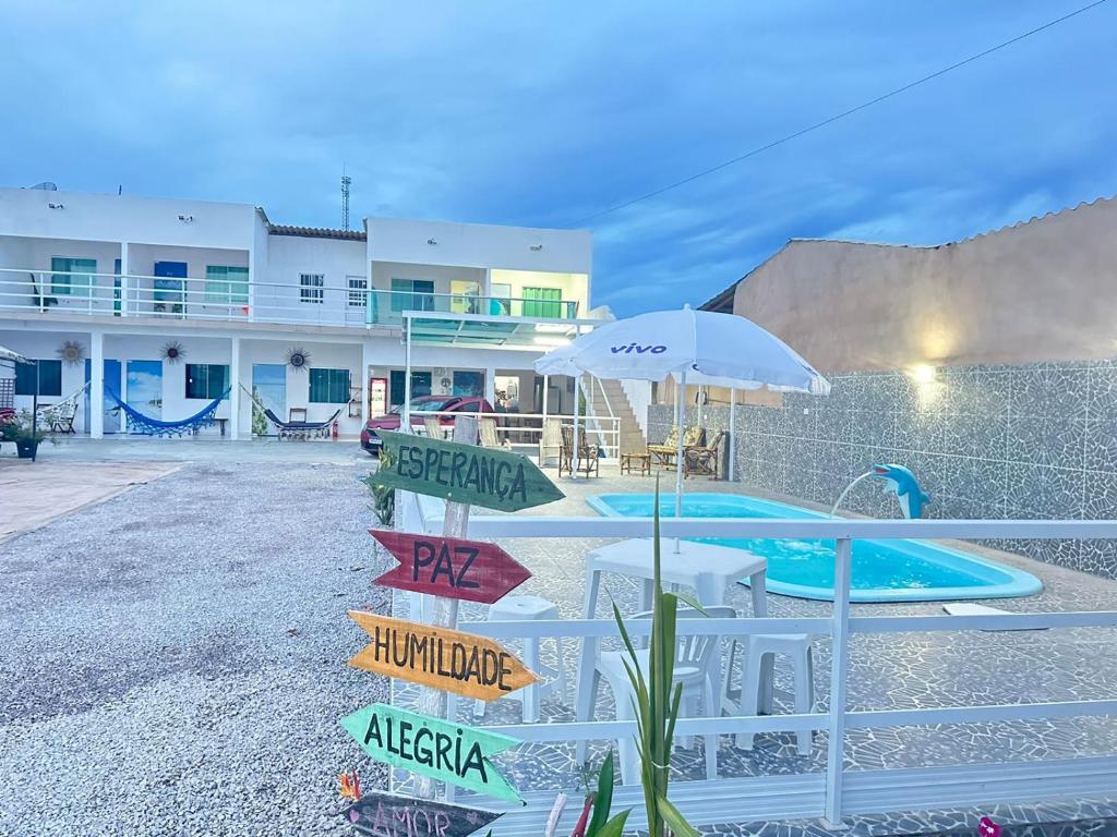 a resort with a swimming pool and a building at Dellas Pousada in Maragogi