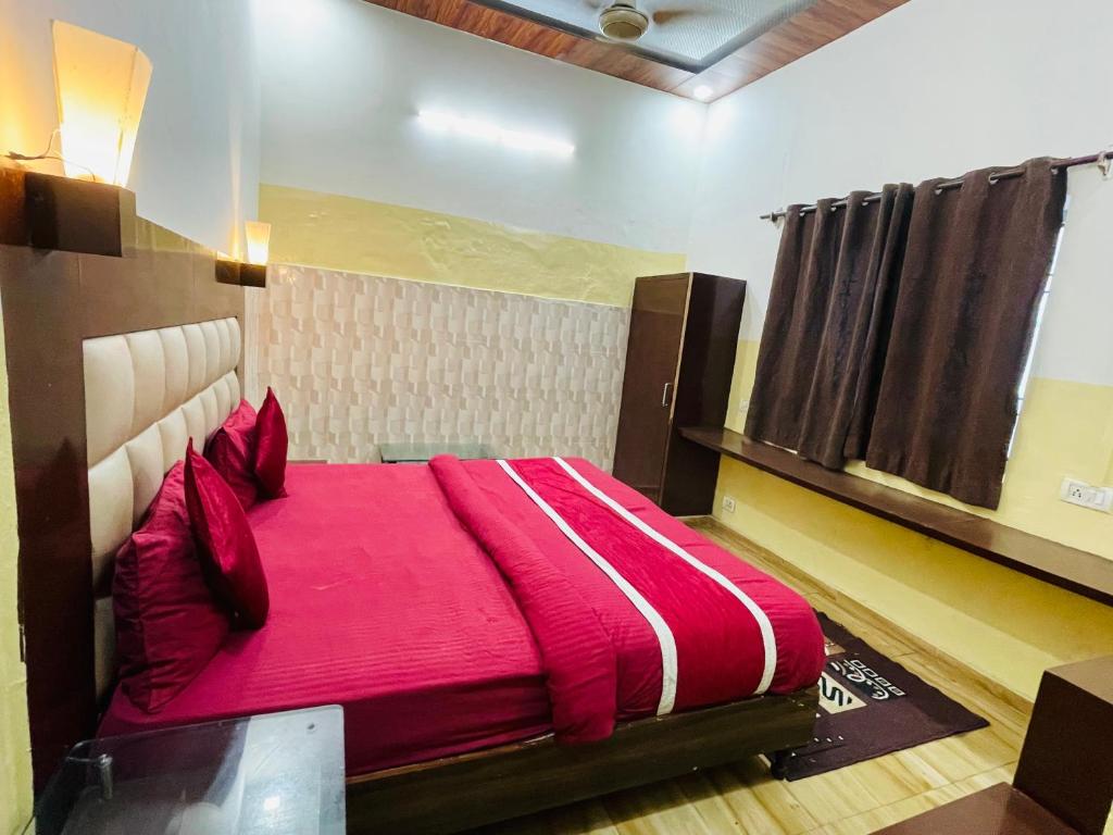 um quarto com uma cama grande e lençóis vermelhos em Hotel Fusion Best Rooms em Agra