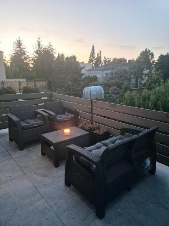 een patio met banken, een tafel en een kaars bij Apartament Brzechwy in Poznań