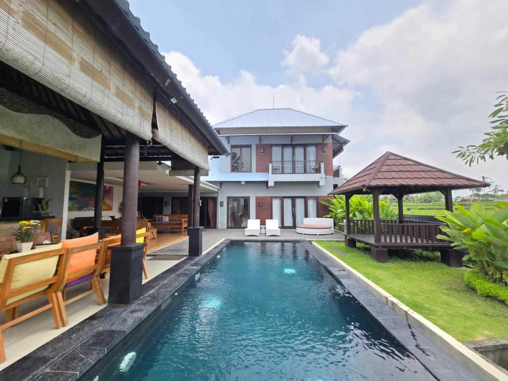 een zwembad in de achtertuin van een huis bij Belvilla 93799 Kasuari Villa Three Bedroom At Taro Village Ubud in Penginyahan