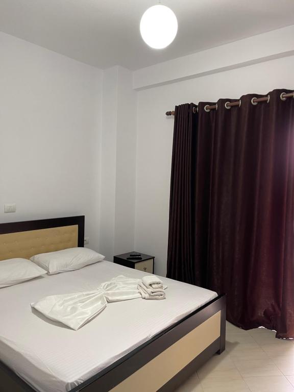 ein Schlafzimmer mit einem Bett mit einem schwarzen Vorhang in der Unterkunft Xhonis Apartments in Ksamil