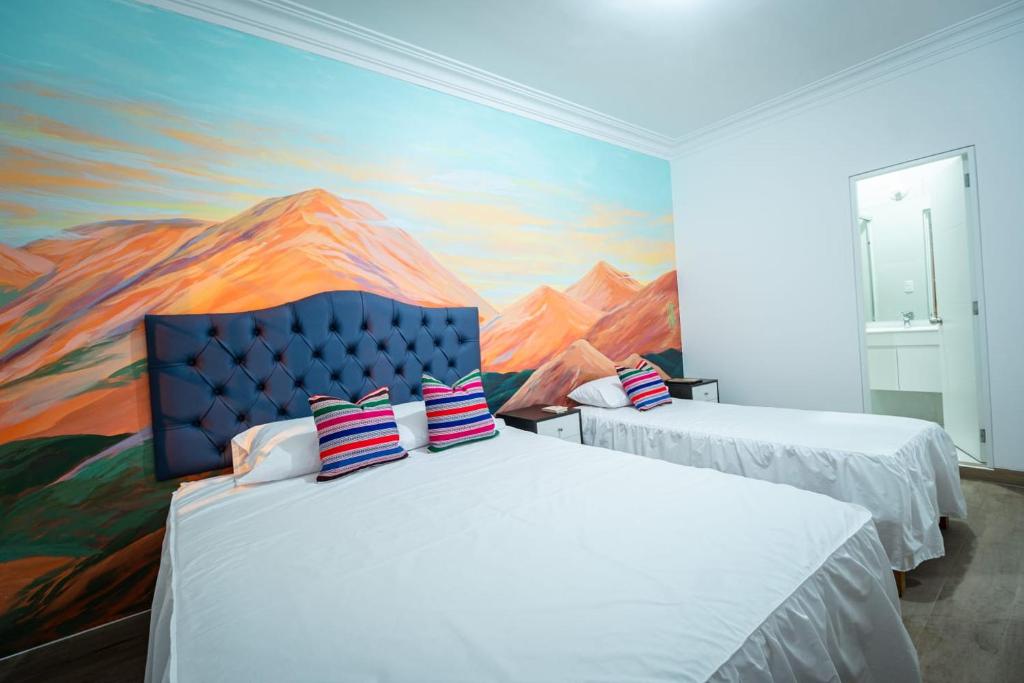 dwa łóżka w pokoju z obrazem na ścianie w obiekcie Casa Águila y Cóndor w mieście Lima