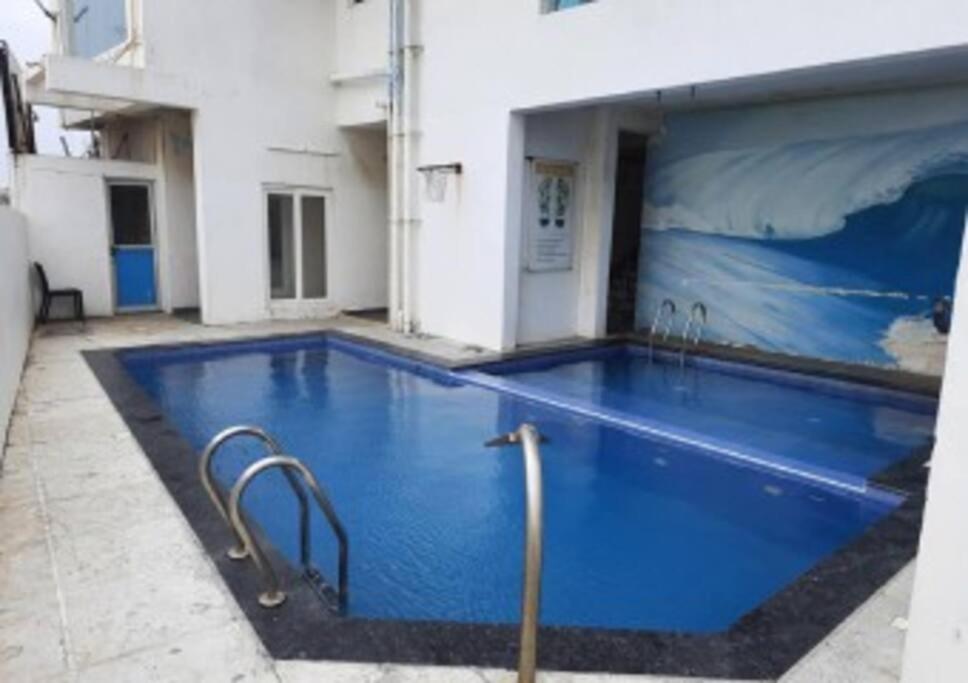 una gran piscina azul en un edificio en Beachfront Bliss: Beautiful Villa in Kovalam, en Covelong