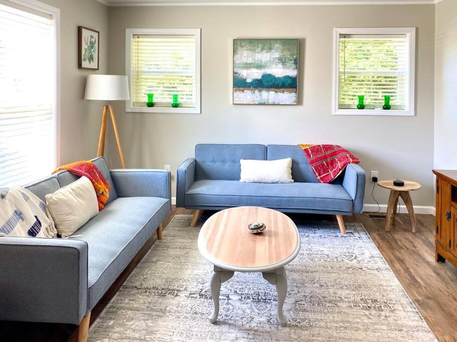 un soggiorno con divano blu e tavolo di Little Pet Friendly House a Greeneville