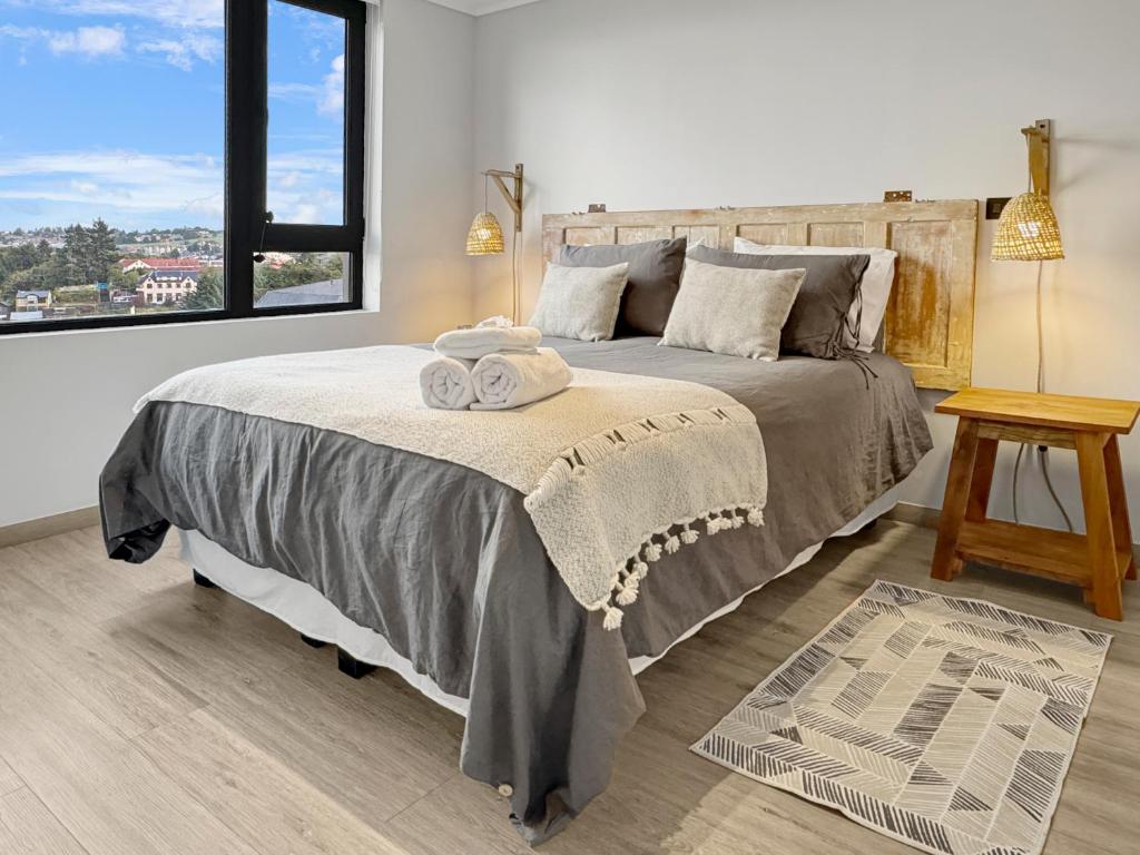 a bedroom with a large bed and a window at La mejor ubicación y nuestro servicio 5 estrellas in Puerto Varas