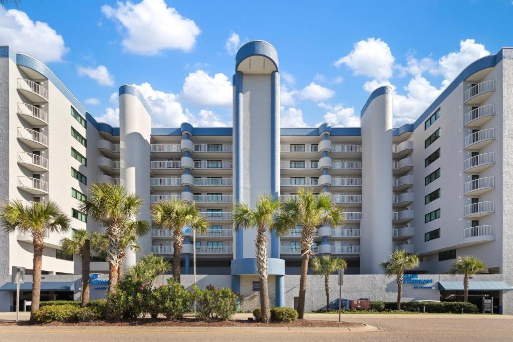 un grand bâtiment avec des palmiers devant lui dans l'établissement Club Wyndham Westwinds, à Myrtle Beach