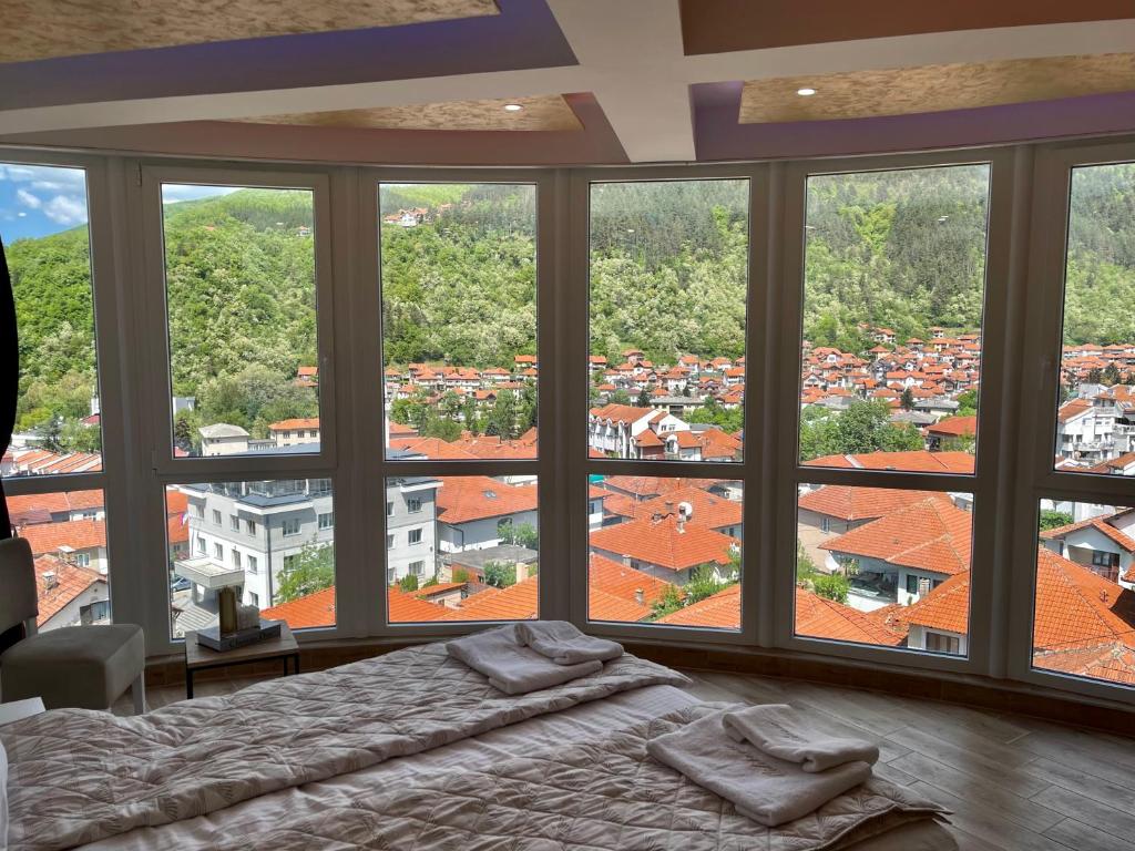 a bedroom with a bed and a view of a city at Apartmani Vidikovac in Prijepolje