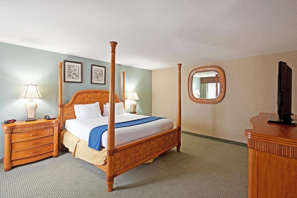 a bedroom with a bed and a dresser and a television at Holiday Inn Express and Suites Meriden, an IHG Hotel in Meriden