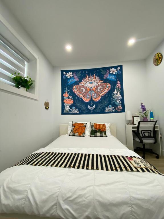 1 dormitorio con 1 cama grande y una pintura en la pared en Sweet home en Surrey