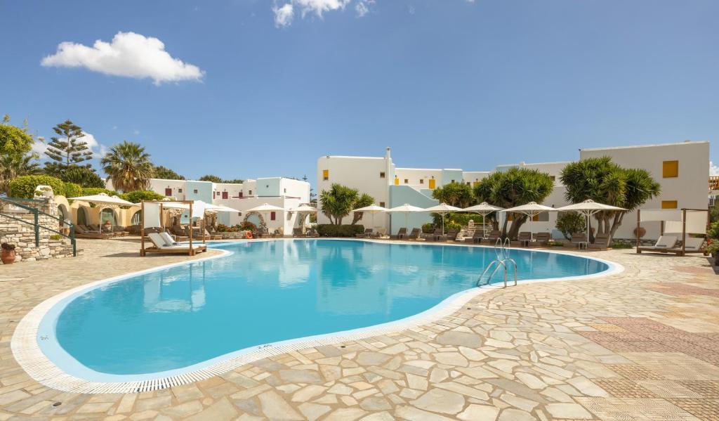 a large swimming pool in a resort with umbrellas at Asteras Paradise in Naousa