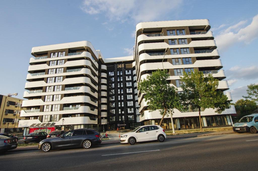 a white car parked in front of a large building at Himson Stylish Studio-Self Check-in near Airport & Mall in Iaşi