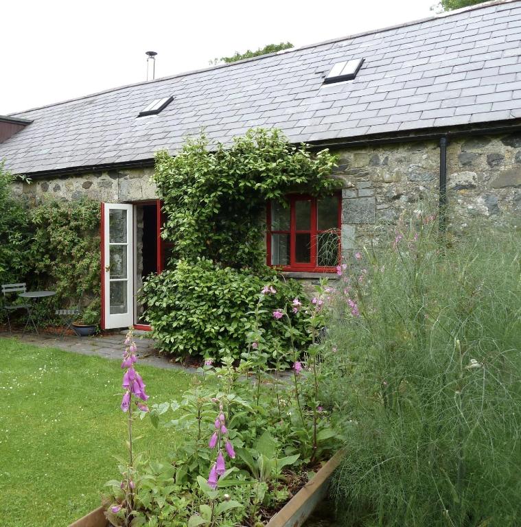 a stone house with a garden in front of it at Y Granor in Pwllheli
