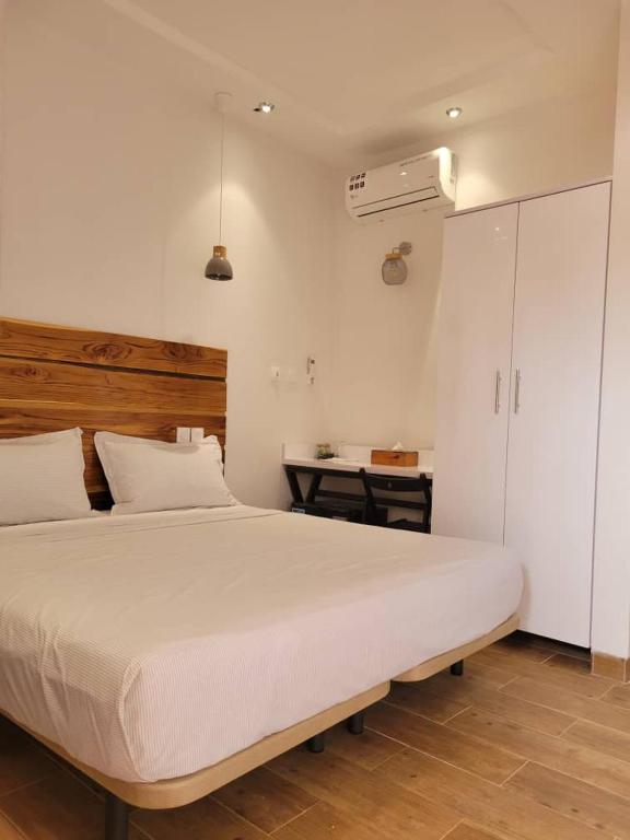 博博迪乌拉Villa Soudan的卧室里有一张白色的大床和一张书桌