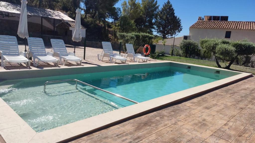una grande piscina con sedie e una piscina di Apartamentos Turísticos Rurales ENTRESIERRAS a Cazorla
